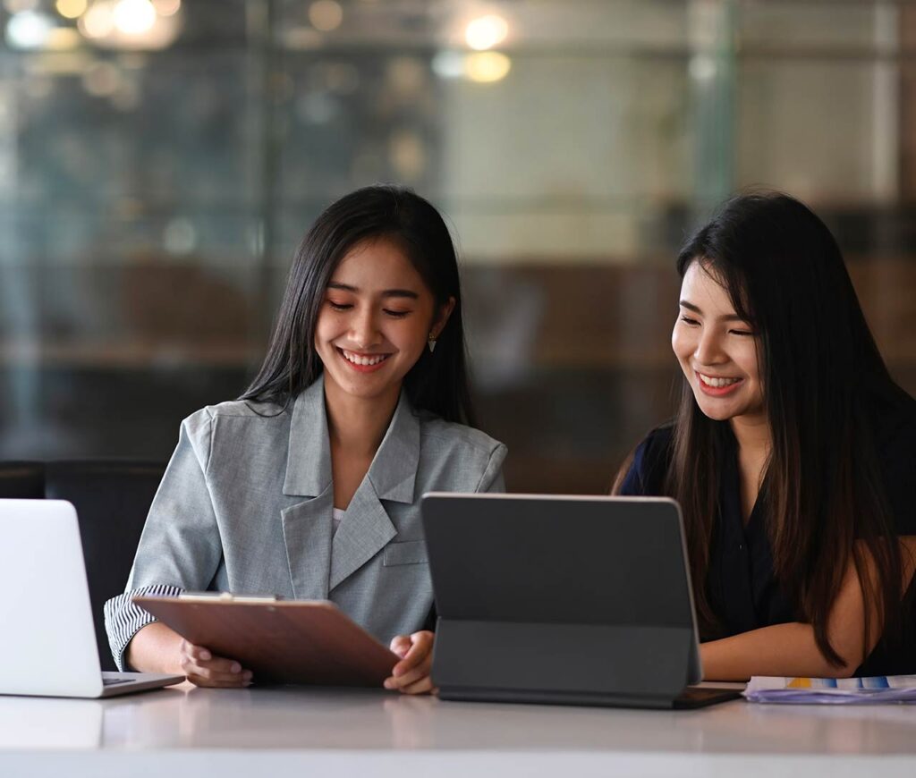 Businesswomen viewing documents on tablet